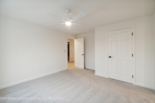 unfurnished bedroom with light colored carpet and ceiling fan