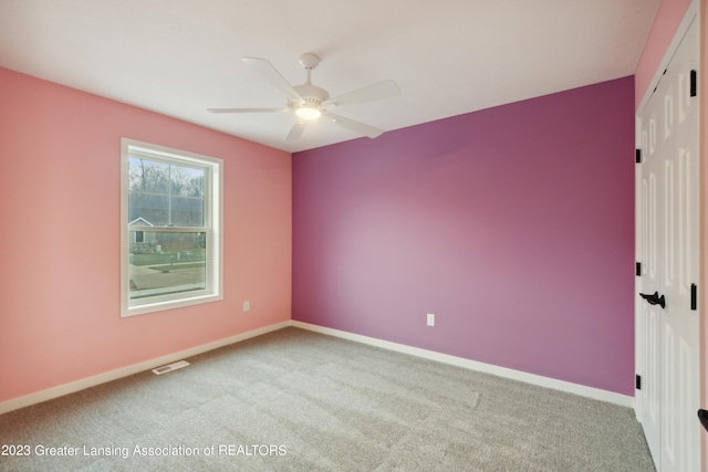 unfurnished room with light colored carpet and ceiling fan