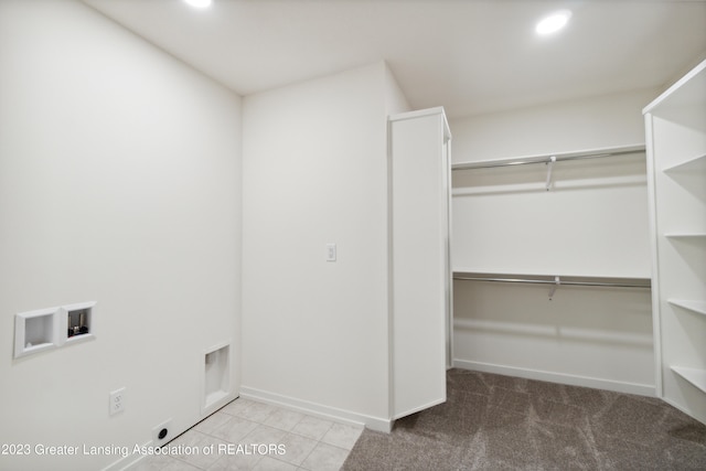 interior space featuring electric dryer hookup, washer hookup, and light tile floors