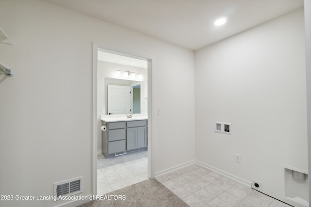 laundry room featuring washer hookup, hookup for an electric dryer, light tile floors, and sink