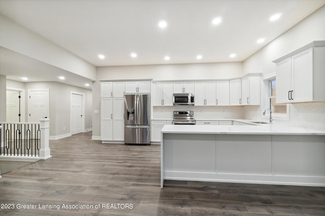 kitchen featuring stainless steel appliances, tasteful backsplash, white cabinets, dark hardwood / wood-style floors, and sink