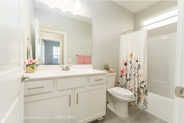 full bathroom featuring wood-type flooring, toilet, shower / bath combination with curtain, and vanity