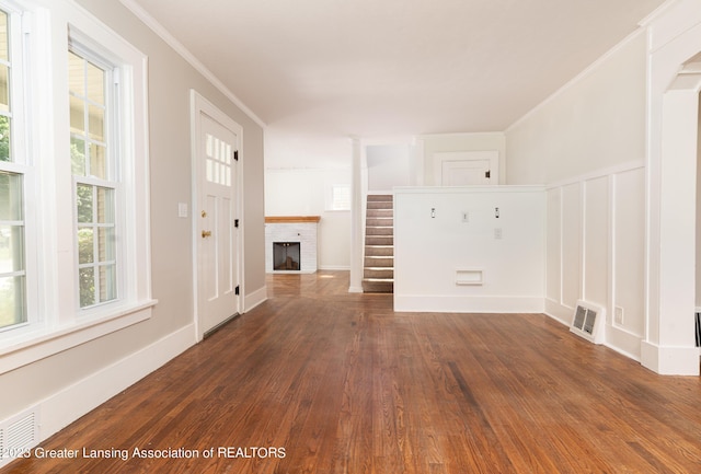 unfurnished living room with dark hardwood / wood-style floors, a fireplace, and crown molding