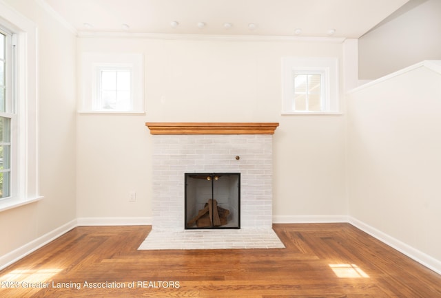 interior details with parquet floors, crown molding, and a brick fireplace