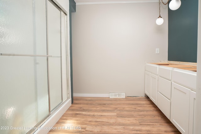 bathroom with vanity, hardwood / wood-style floors, and a shower with shower door