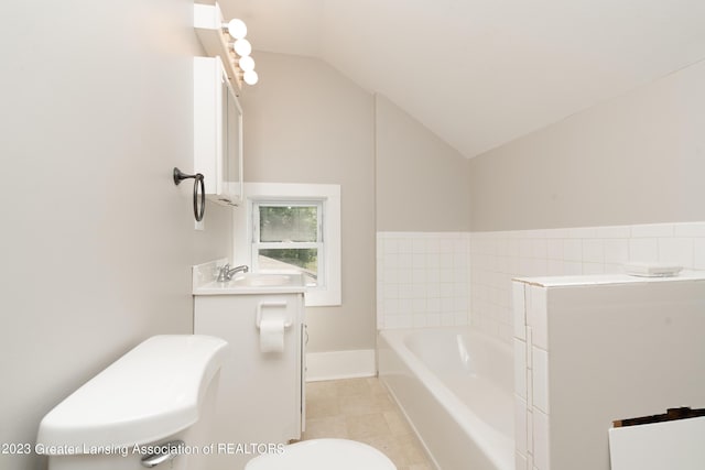 bathroom featuring a bathing tub, lofted ceiling, vanity, and toilet