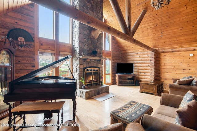 living room featuring a stone fireplace, rustic walls, high vaulted ceiling, and light hardwood / wood-style floors