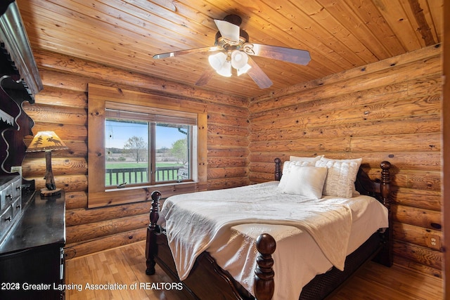 bedroom with wood ceiling, ceiling fan, log walls, and hardwood / wood-style flooring