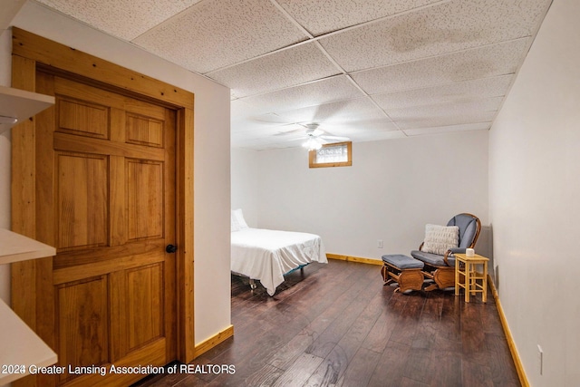 bedroom featuring a paneled ceiling, dark hardwood / wood-style floors, and ceiling fan