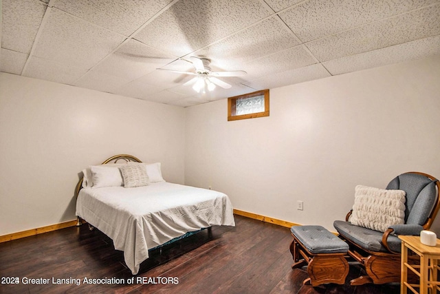 bedroom with a paneled ceiling, ceiling fan, and dark hardwood / wood-style flooring