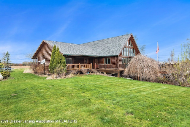 rear view of property with a wooden deck and a lawn