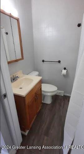 bathroom featuring vanity, toilet, and hardwood / wood-style floors