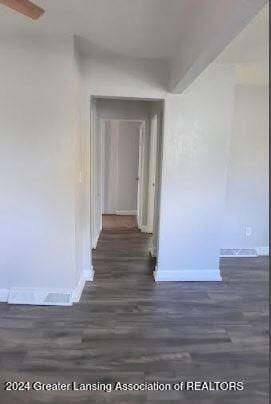 corridor with dark hardwood / wood-style flooring