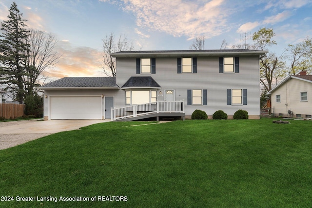 view of property featuring a garage and a lawn