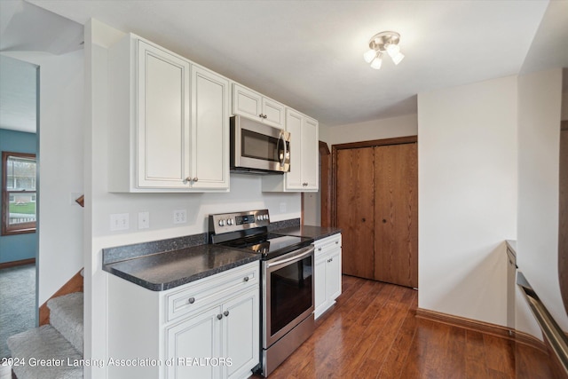 kitchen with appliances with stainless steel finishes, dark hardwood / wood-style floors, and white cabinets