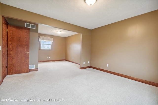 unfurnished room featuring carpet flooring and a textured ceiling