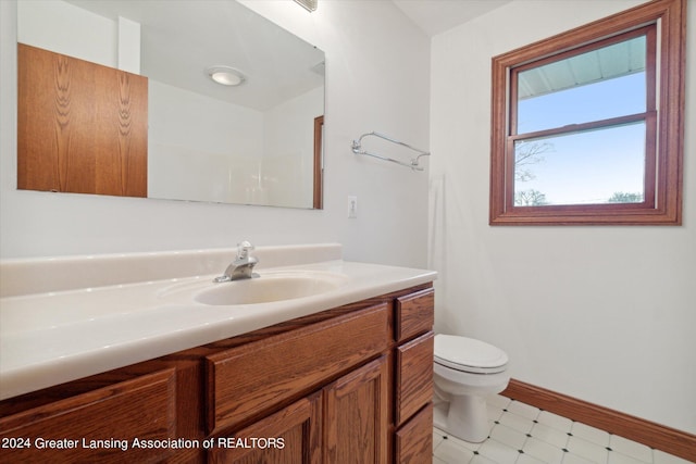 bathroom featuring toilet, tile flooring, and vanity