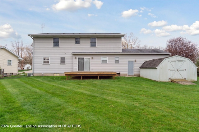 back of property with a lawn, a shed, and central air condition unit