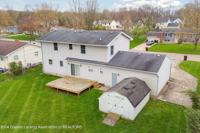 rear view of house featuring a shed and a yard