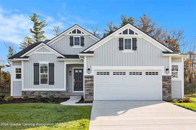 craftsman house featuring a garage and a front lawn