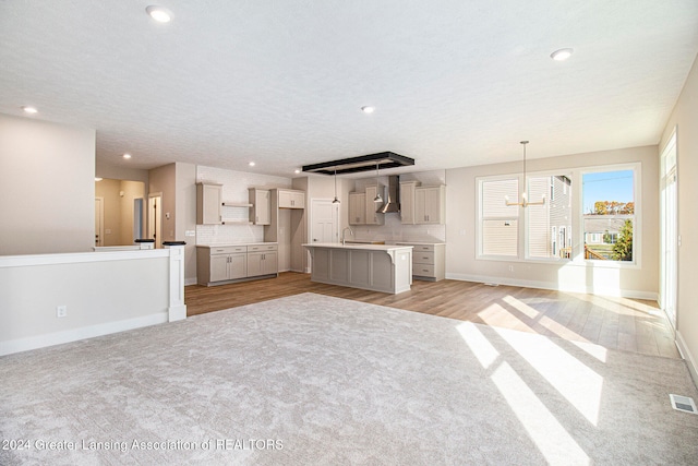 unfurnished living room with light hardwood / wood-style floors and a textured ceiling