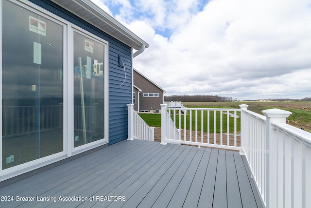 wooden deck featuring a lawn