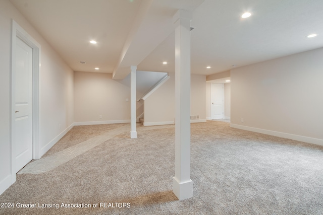 basement featuring light carpet