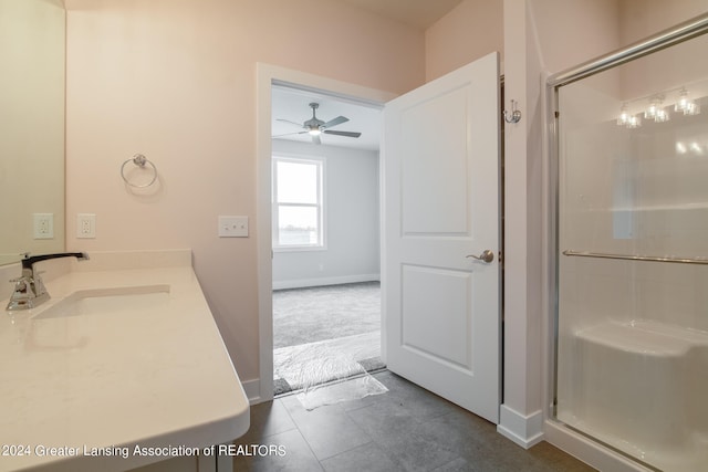 bathroom featuring a shower with door, sink, ceiling fan, and tile floors