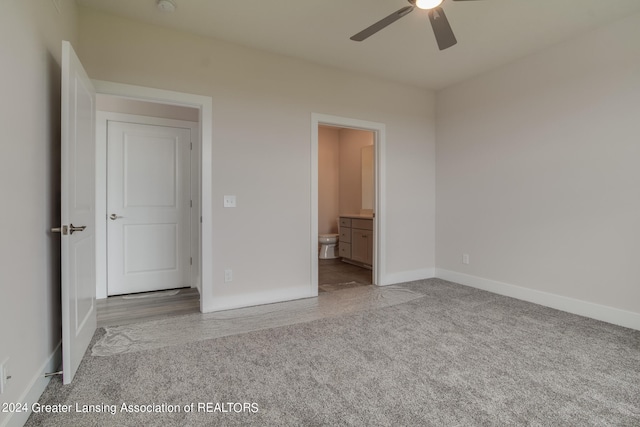 unfurnished bedroom with ceiling fan, ensuite bathroom, and carpet flooring