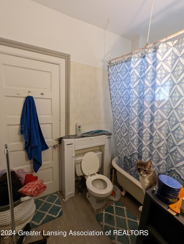 bathroom featuring tile walls and toilet