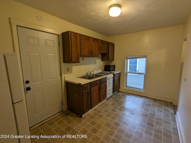 kitchen with sink, dark brown cabinets, white appliances, and tile floors