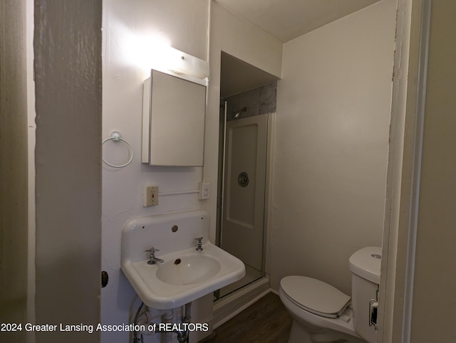 bathroom with hardwood / wood-style floors, walk in shower, and toilet