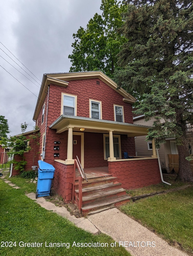 view of front of property with covered porch and a front lawn