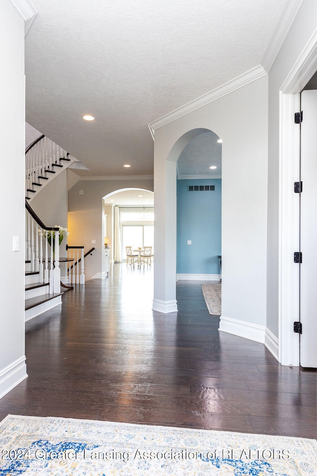 empty room featuring ornamental molding and dark wood-type flooring