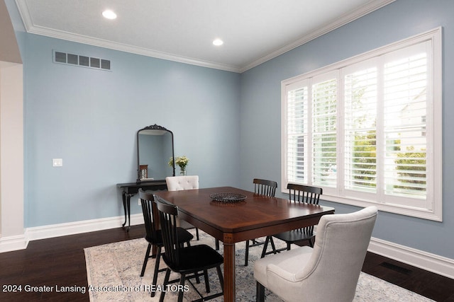 dining room with dark hardwood / wood-style flooring and crown molding