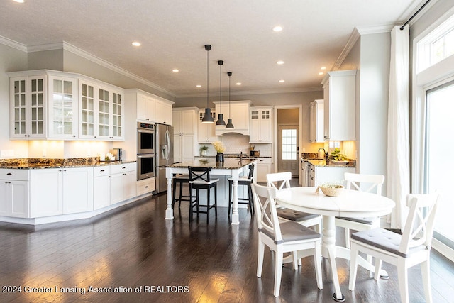 dining space featuring dark hardwood / wood-style floors, sink, and crown molding