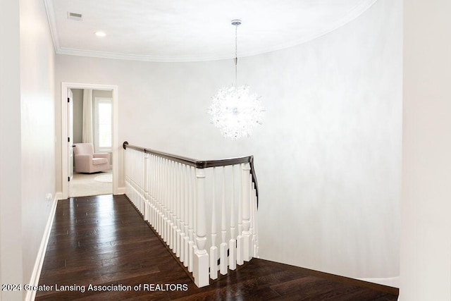 stairs with hardwood / wood-style floors, ornamental molding, and a chandelier