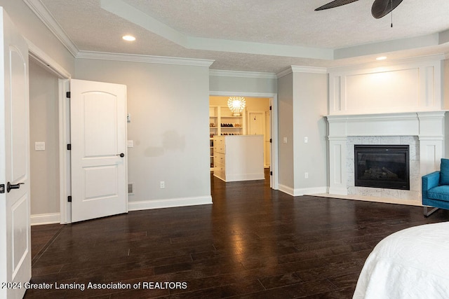 unfurnished bedroom with a textured ceiling, ceiling fan, a high end fireplace, and dark hardwood / wood-style floors