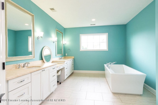 bathroom featuring tile patterned floors, a washtub, and vanity