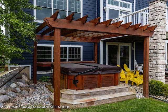 exterior space with a pergola and a hot tub