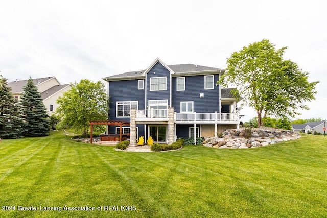 back of property featuring a yard, a deck, and a pergola