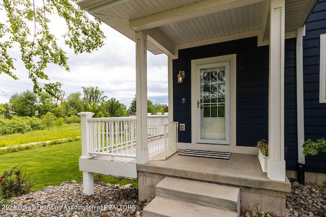 property entrance with a lawn and a porch