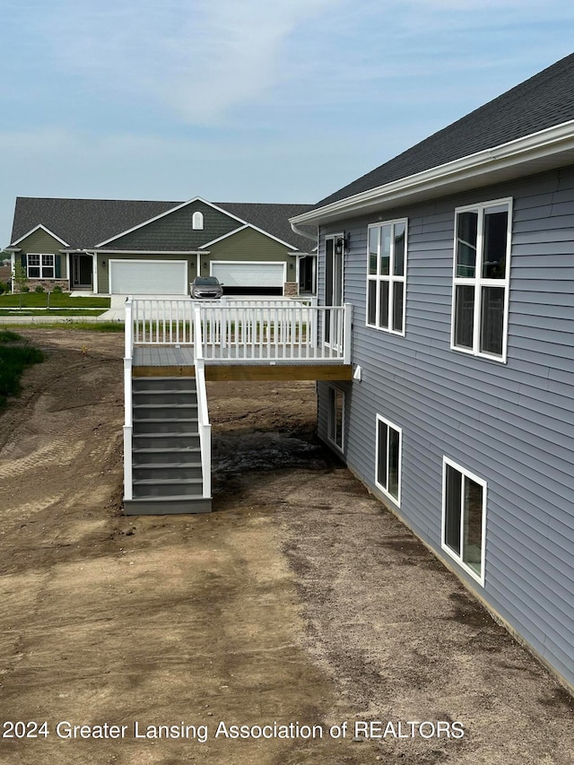 rear view of house with a garage and a wooden deck