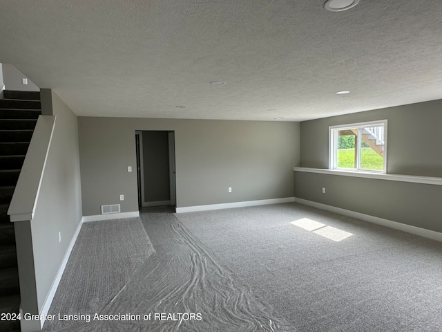 unfurnished room with a textured ceiling and carpet flooring