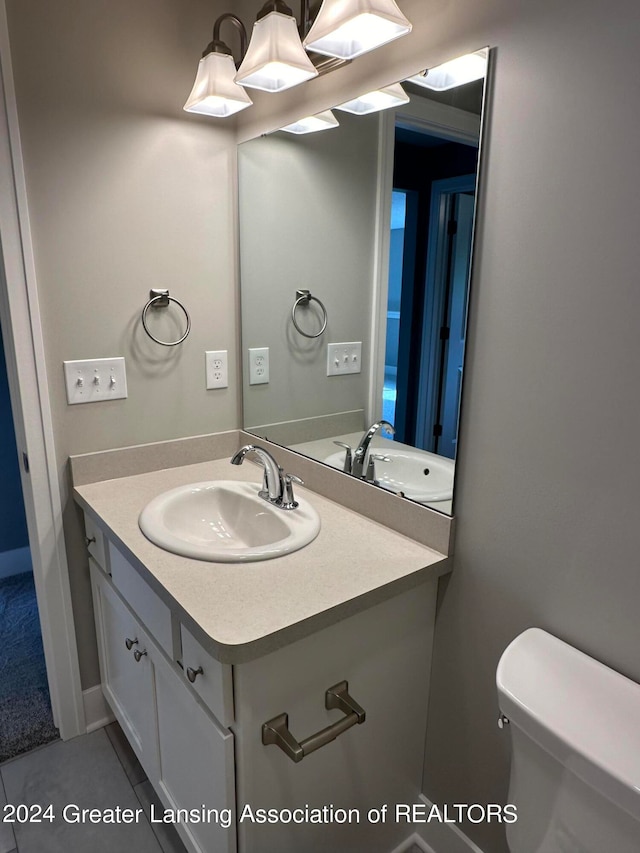 bathroom featuring tile floors, toilet, and vanity with extensive cabinet space