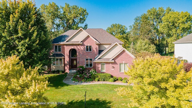 traditional home featuring brick siding and a front yard