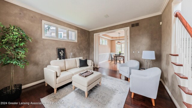 living room featuring dark wood-style floors, ornamental molding, visible vents, and baseboards