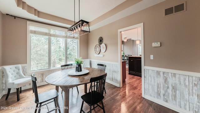 dining area featuring wainscoting, visible vents, and wood finished floors