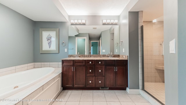 bathroom with double vanity, a stall shower, a sink, tile patterned flooring, and a bath