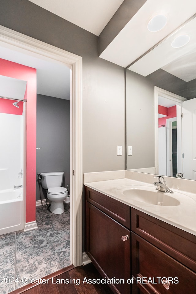 bathroom featuring shower / bathing tub combination, vanity, toilet, and baseboards